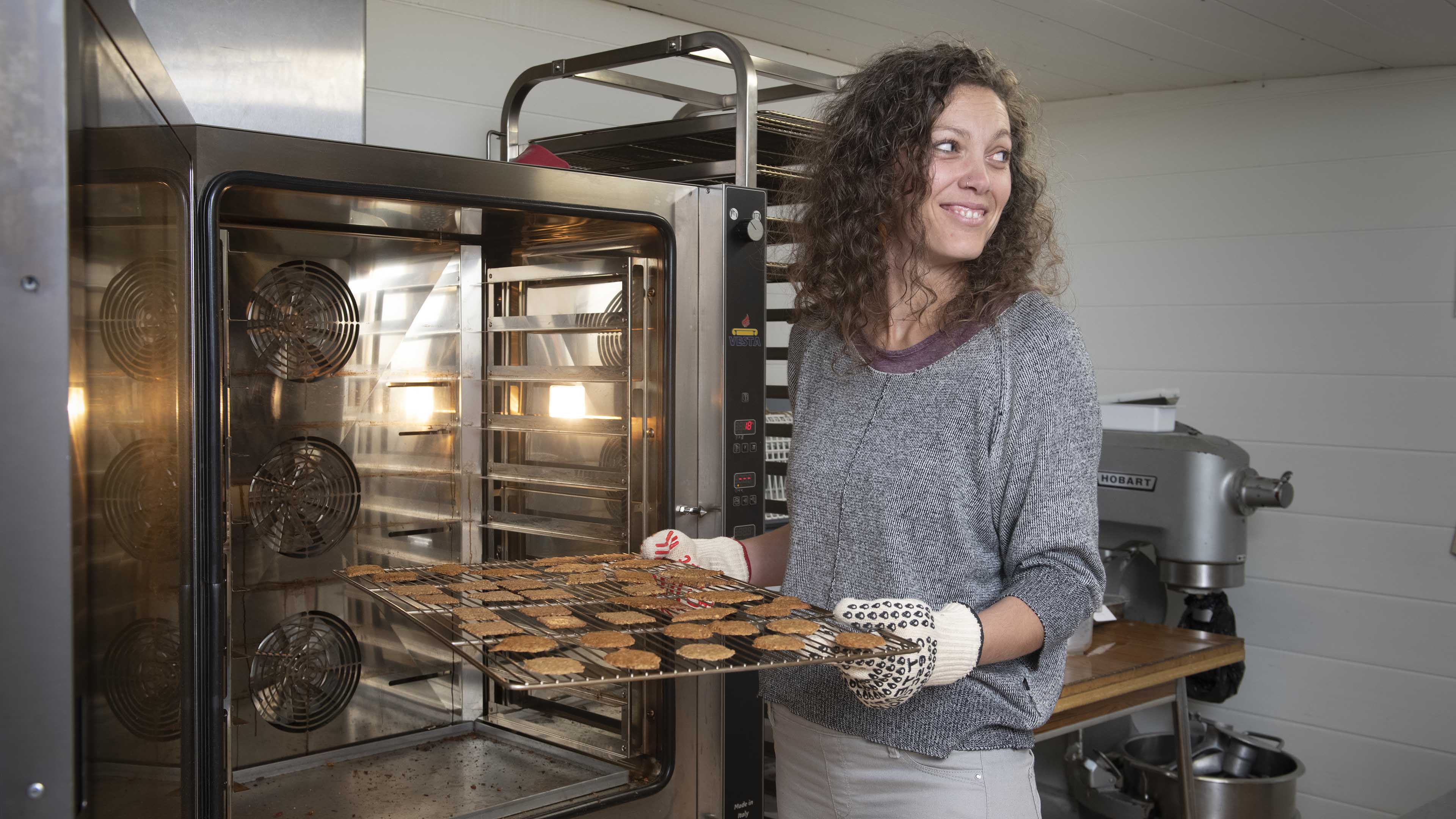 jeune femme devant un four à gateaux